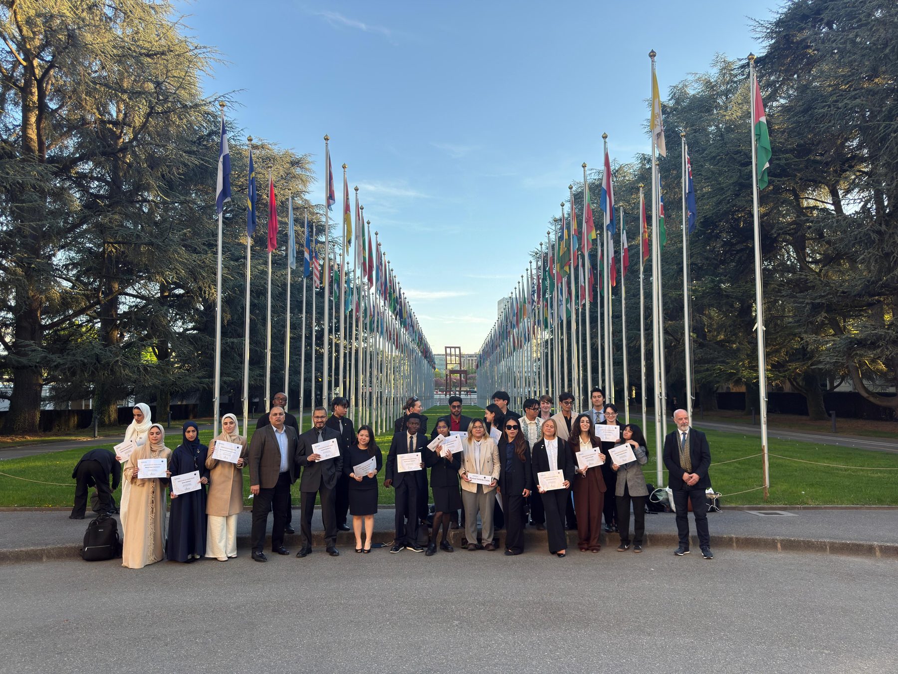 The full international cohort holding certificates at the Allee des Nations